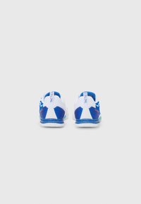 Zapatillas deportivas con una base blanca, acentos azules, parte superior de malla texturada y suela de goma. Presenta un diseño de talón prominente y detalles de logo.