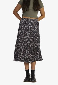 Black floral midi skirt with a loose fit, featuring a waist tie, small colorful flower patterns, and lightweight fabric texture.