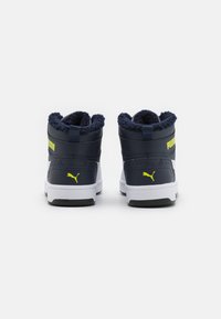 Sneaker alte in blu navy e bianco, con un colletto peloso, accenti di logo gialli e una suola in gomma testurizzata.