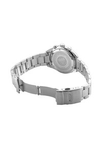 Reloj de pulsera de metal plateado con cierre abierto que muestra la parte trasera grabada marcada con "1888 Roamer Switzerland" y detalles con patrón circular.
