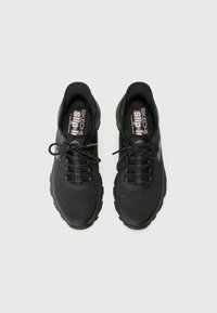 Zapatos deportivos negros con parte superior de malla, punta redonda, cordones y suela de goma moldeada. Presentan acentos redondeados y plantilla acolchada.