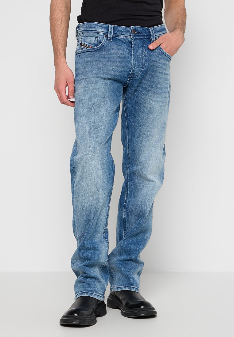 Jeans in denim azzurro chiaro con taglio dritto, cinque tasche e chiusura frontale con bottone. Presentano una leggera scoloritura e un design classico.