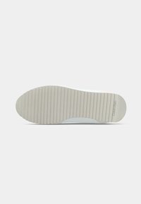 Witte sneakerzool met een geribbelde textuur, voorzien van een ronde vorm en subtiele branding. Het materiaal lijkt rubberachtig en duurzaam.