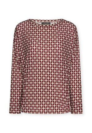 Blusa de manga larga con un fondo crema y un patrón abstracto de puntos en color marrón oscuro. Tejido suave con un cuello redondo y un corte holgado.
