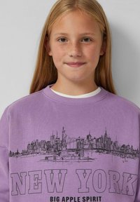 Felpa viola con un'illustrazione nera dello skyline di New York City, con il testo "NEW YORK" in evidenza nella parte inferiore.