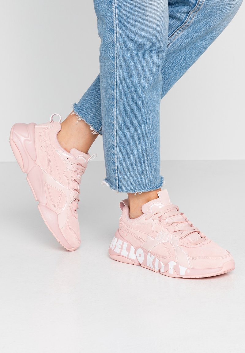 Baskets de sport roses avec un dessus texturé et des accents lisses, bout rond et marquage "HELLO KITTY" sur la semelle.