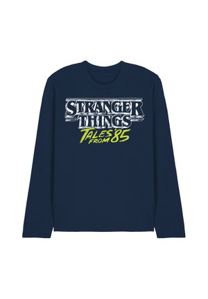 Navy long-sleeve shirt with white and neon green text reading "Stranger Things Tales from 85" on the front center.
