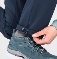 Sportliche Schuhe in Türkis, mit strukturiertem Material und Schnürung. Kombiniert mit Navy-Hosen, die verstellbare Bündchen und seitliche Falten besitzen.