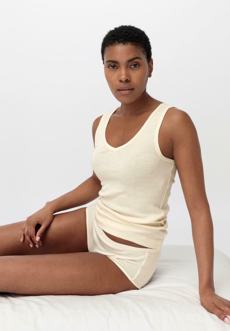 Beige, sleeveless tank top and matching boyshorts made of soft, lightweight fabric. Features a scoop neckline and side cutouts on shorts.