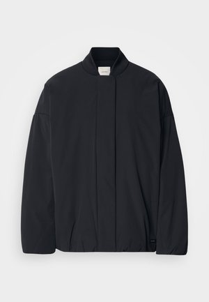 Veste noire à manches longues avec un col côtelé, fermeture frontale cachée et une étiquette de marque discrète au bas de l'ourlet, posée à plat sur un fond blanc.