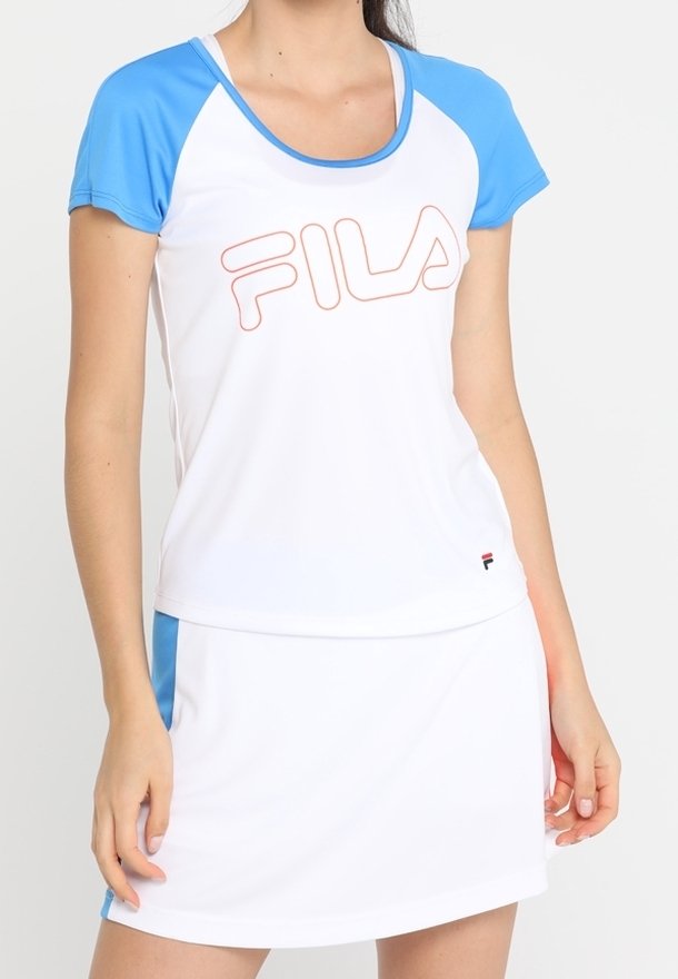Vit träningströja med blå raglanärmar, prydd med en orange FILA-logotyp. Matchad med en vit kjol som har blå detaljer.