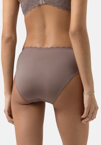 Slip a vita alta in un morbido mauve tenue con una texture liscia e soffice, e una rifinitura in pizzo in vita. Presenta lati senza cuciture per un maggiore comfort.