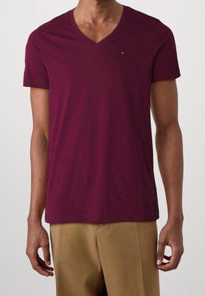 Bordeaux bomulds v-hals t-shirt med korte ærmer og et lille logodetalje på brystet, parret med beige bukser.