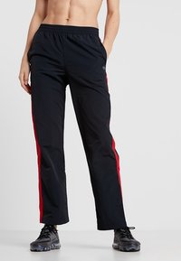 Zwarte sportbroek met rode zijstrepen, gemaakt van lichtgewicht materiaal, met een elastische tailleband en een comfortabele pasvorm.