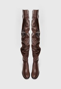 Botas marrones hasta la rodilla, hechas de cuero suave, con un diseño texturizado y suelto, puntera redonda y suela plana con cremalleras laterales.