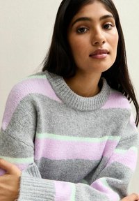 Suéter de punto gris con rayas en tonos rosa pastel y verde menta, que presenta un cuello y puños acanalados, una textura suave y un ajuste relajado.