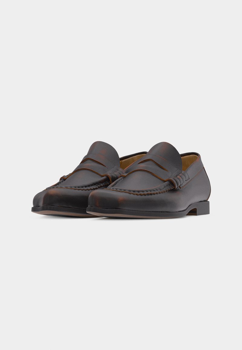 Pair of dark brown leather penny loafers with detailed stitching and low heels on a plain light background.
