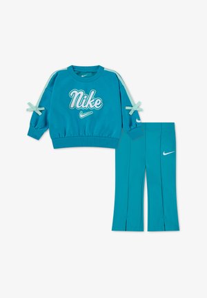 Teal Nike sweatshirt med hvidt logo og sløjfer på ærmerne kombineret med matchende teal bukser med hvide Nike swoosh logoer.