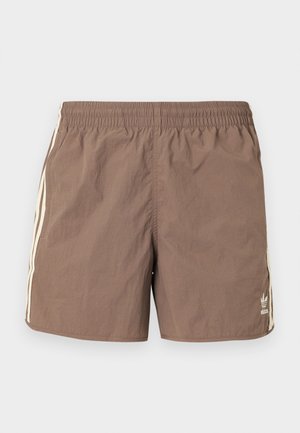 Rjavi najlonki kopalke s elastiko v pasu, z vanilje obrobami na straneh in majhnim logotipom na spodnjem levem delu.