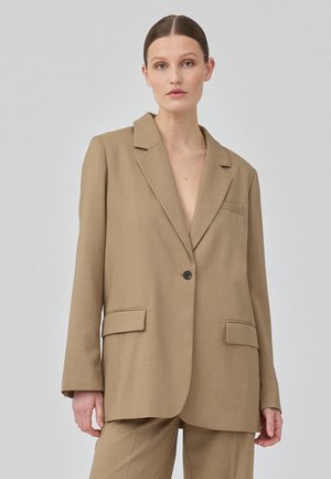 Tan tailored blazer made of textured fabric. Features a single button closure, notched lapels, and two front pockets.