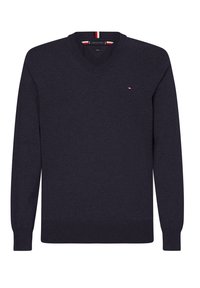 Granatowy sweter z dekoltem w serek, wykonany z miękkiej dzianiny, z długimi rękawami i małym logo na piersi, z czerwonymi i białymi akcentami wewnątrz kołnierza.