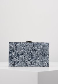 Clutch metallico rettangolare con finitura argentata increspata. Dotato di chiusura a scatto e texture liscia. Base solida, design minimalista.