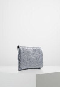 Srebrna metaliczna syntetyczna torebka kopertówka z teksturowaną powierzchnią i gładkimi krawędziami, charakteryzująca się minimalistycznym designem.