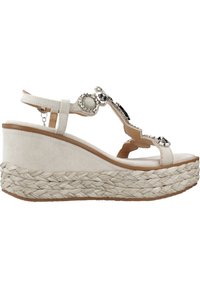 Sandalias de cuña beige con un acabado en ante texturizado, correa adornada con piedras decorativas claras y negras, y suela de cuerda trenzada.