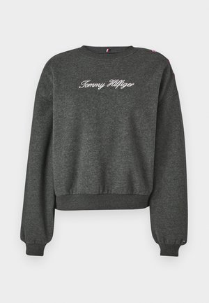 Grijze sweatshirt met een cropped ontwerp, met lange mouwen en ribbelmanchetten. "Tommy Hilfiger" is in het wit geborduurd op de voorkant.