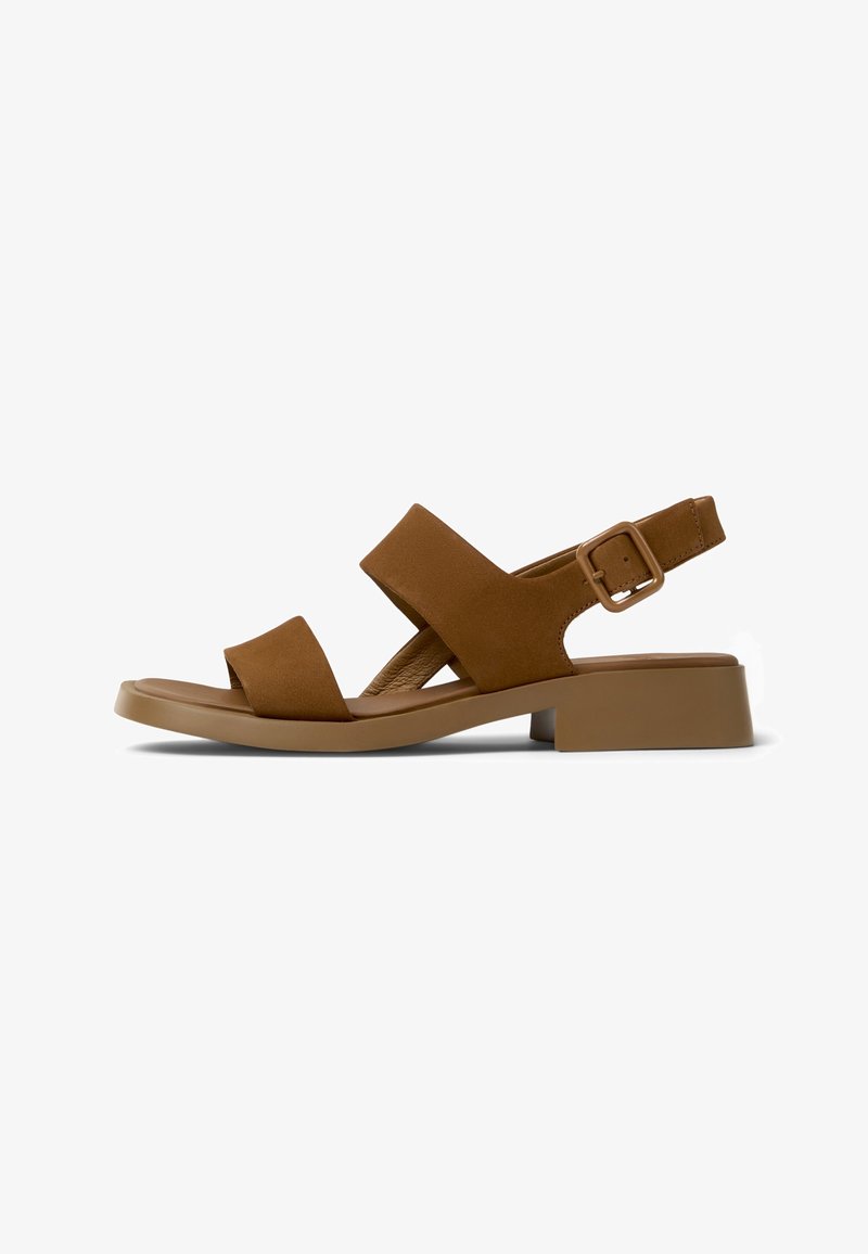 Sandale marron à bout ouvert avec deux larges brides, un petit talon carré et une bride de cheville ajustable avec boucle sur fond blanc.
