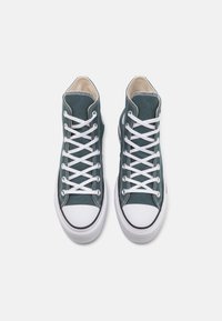 Tengernyi vászonból készült, fehér fűzővel, fekete részletekkel és gumitalppal rendelkező, tűsarkú tornacipők. Sima felület és klasszikus dizájn.