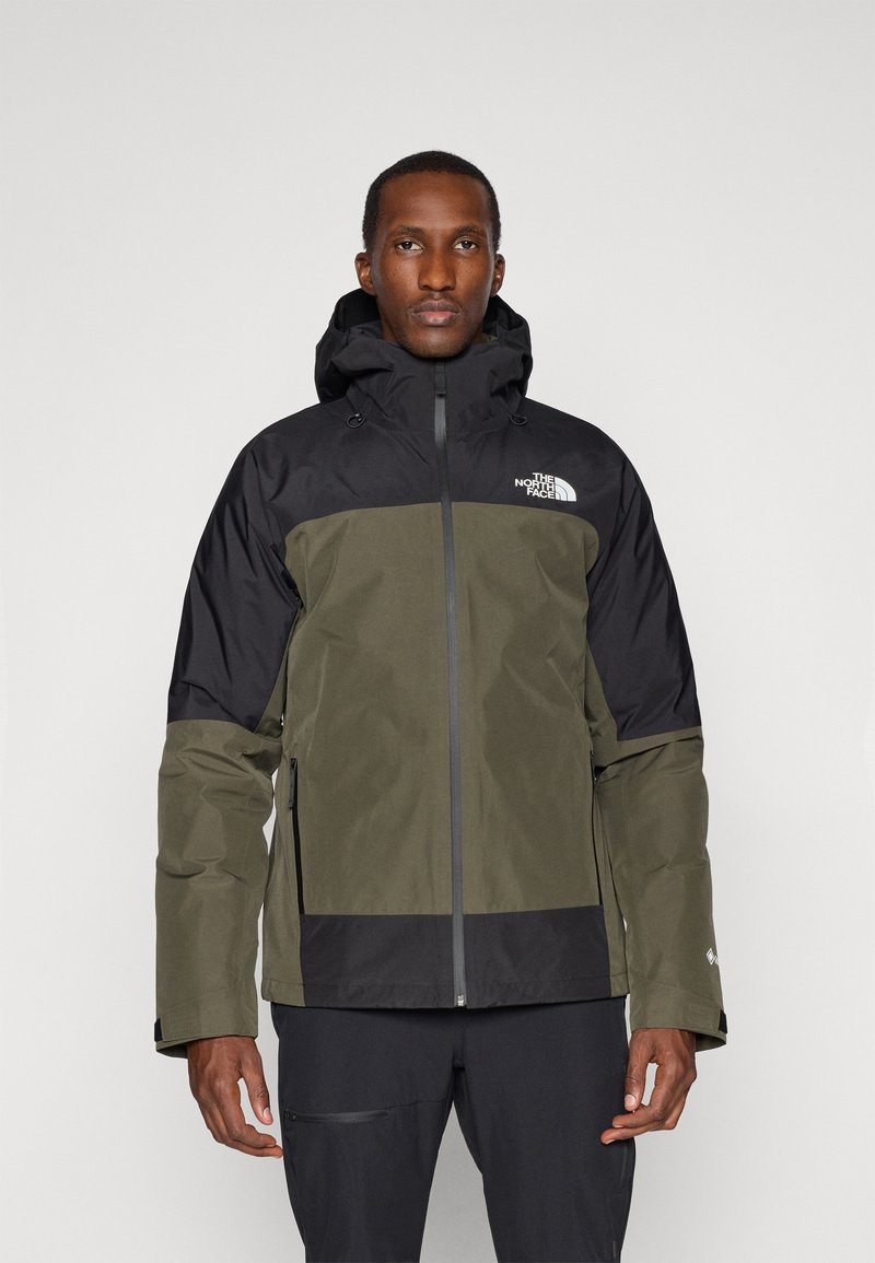 Veste imperméable avec un schéma de couleurs noir et vert olive, dotée d'une fermeture éclair à l'avant, d'une capuche ajustable et d'un logo sur la poitrine.