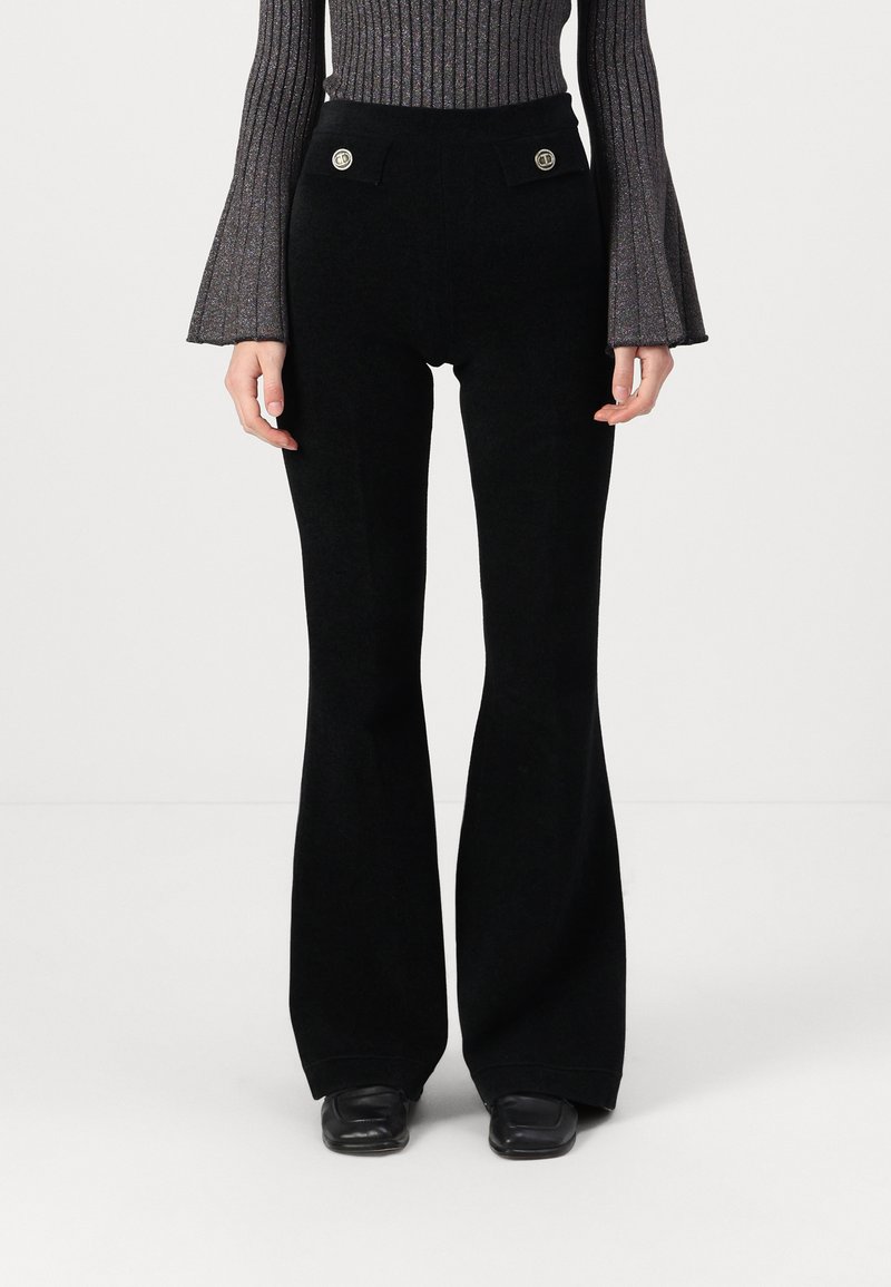 Pantalons évasés noirs avec une texture lisse, taille haute et deux poches avant avec des accents de boutons dorés.