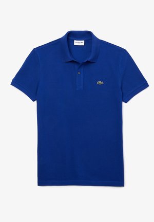 Blauwe katoenen polo met een klassieke kraag, korte mouwen en een groen Lacoste-logo geborduurd op de linkerkant van de borst. Eenvoudig ontwerp.