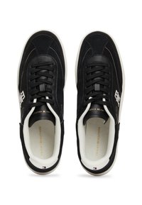 Mustat tennarit, jotka on valmistettu mokasta ja synteettisistä materiaaleista. Varustettu nauhakiinnityksellä, valkoisilla ompeleilla ja kontrastivärisellä kumipohjalla.