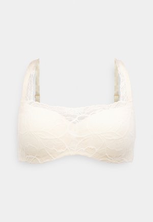 Bralette de encaje en crema, con patrones florales, tirantes de satén ajustables y un acabado suave. Diseñado sin aros para mayor comodidad.
