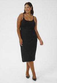 Abito midi nero senza maniche con una silhouette aderente, realizzato in tessuto morbido. Sottolinea la forma del corpo con dettagli di design minimi.