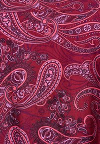 Rdeča tkanina z zapletenimi paisley in cvetličnimi vzorci v roza in črni barvi. Gladka tekstura, ki vsebuje vijugaste motive in fino detajliranje.