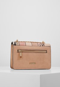 Borsa a tracolla compatta in morbida pelle rosa chiaro con una zip dorata, tracolla a catena e un accento in stampa serpente multicolore.