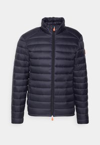 Granatowa kurtka puchowa o pikowanym wzorze, z wysokim kołnierzem i zapięciem na zamek. Pomarańczowy uchwyt na zamku. Długie rękawy i dopasowany krój.