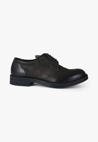 Scarpa nera in pelle con punta arrotondata, design classico con stringhe e superficie testurizzata. Presenta una suola in gomma bassa e dettagli di cucitura sottili.