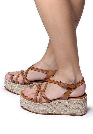Braune Leder-Plateausandalen mit gekreuzten Riemen, einer geflochtenen Jute-ähnlichen Sohle und einer leichten Textur. Mit einem Knöchelriemen und einer weichen Fußbett ausgestattet.