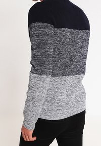 Męski sweter dziany z granatową górą, szarym środkiem i jasnoszarym dołem, z fakturowanym wzorem i żebrowanym kołnierzem.