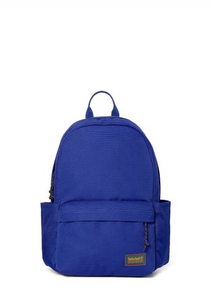 Robust blå rygsæk med frontlomme med lynlås, sidelommer, topgreb og Timberland-logo på nederste højre hjørne.