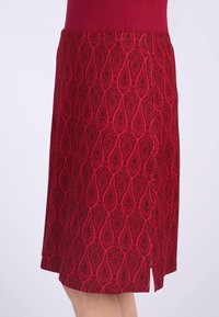 Roter Rock mit Paisleymuster, der einen leichten Schlitz hat. Aus strukturiertem Stoff gefertigt, mit taillierter Oberseite und A-Linien-Form.