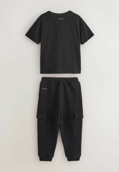 Mustikka puuvillapaita lyhyillä hihoilla ja pyöreällä kaula-aukkolla, yhdistettynä vastaaviin collegehousuihin, joissa on cargo-taskut ja ribattu helmari.