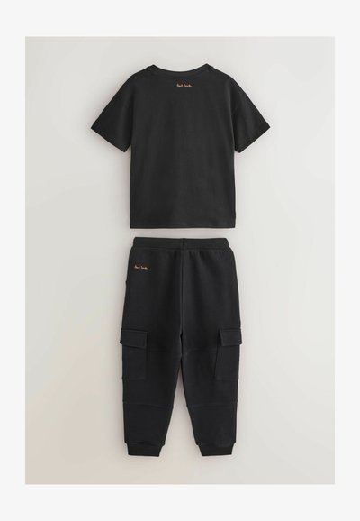 Mustikka puuvillapaita lyhyillä hihoilla ja pyöreällä kaula-aukkolla, yhdistettynä vastaaviin collegehousuihin, joissa on cargo-taskut ja ribattu helmari.