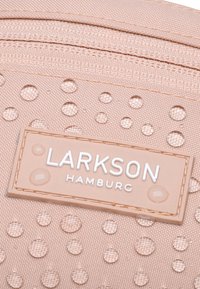 Borsa in tessuto rosa con superficie testurizzata e punti in rilievo. Logo LARKSON HAMBURG in bianco su un'etichetta rettangolare. Cerniera superiormente.