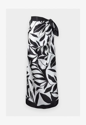 Black and white leaf-patterned sarong tied at the waist, made of smooth, silky fabric.
