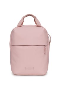 Mochila rosa hecha de material suave, con asas cortas, un bolsillo frontal con cremallera y una forma rectangular con un sutil detalle de logo.